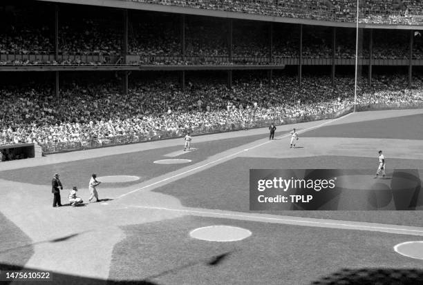 Minnie Minoso of the Chicago White Sox gets ready to bunt as pitcher Jim Coates of the New York Yankees goes into his wind-up during an MLB game at...