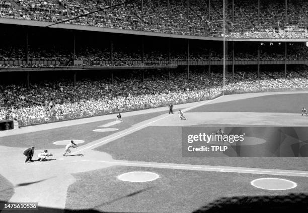 Minnie Minoso of the Chicago White Sox lays down the bunt off of pitcher Jim Coates of the New York Yankees during an MLB game at Yankee Stadium in...