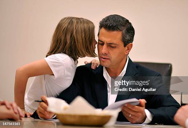 Presidential candidate Enrique Pena Nieto of the Institutional Revolutionary Party talks with his daughter Regina as he awaits the election results...
