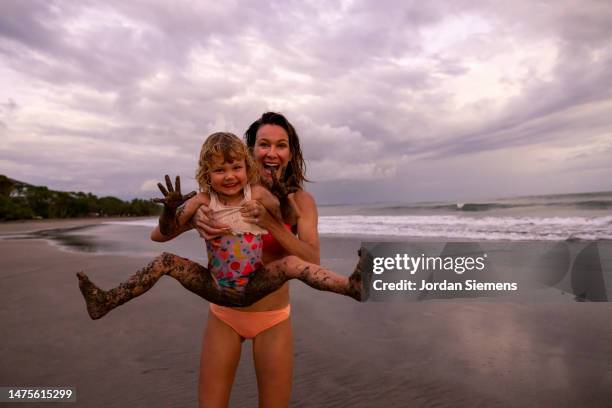 a woman and her daughter enjoying a day at the beach while on vacation. - a child playing in a mess stock pictures, royalty-free photos & images