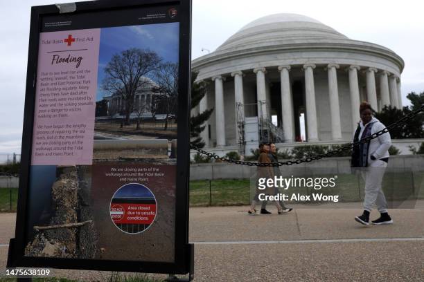 Poster regarding flooding due to sea levels rising in the area is on display in front of the Thomas Jefferson Memorial amid cherry blossoms in peak...