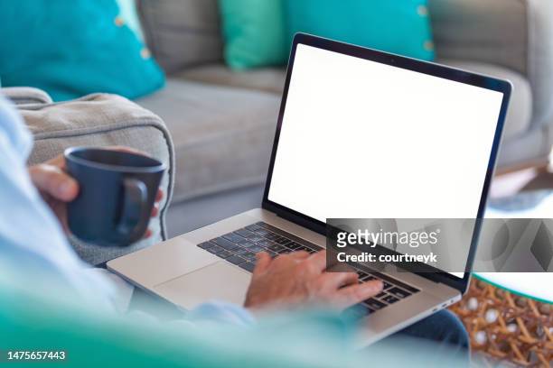reifer mann, der zu hause einen leeren laptop benutzt. - blank laptop screen stock-fotos und bilder