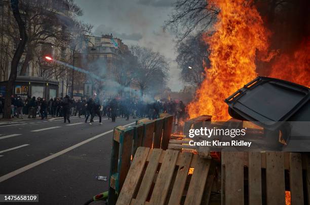 Protestors shoot fireworks toward riot police as demonstrations against the government's reform of the pension system turned violent on March 23,...