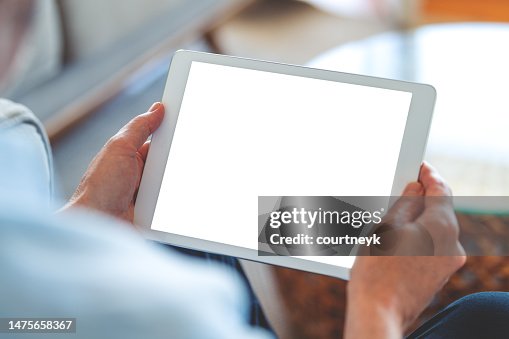 Mature man using a blank screen digital tablet at home. Mature man using a blank screen digital tablet at home.