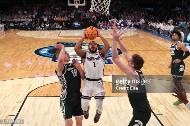 Markquis Nowell of the Kansas State Wildcats shoots the ball against Joey Hauser and Jaxon Kohler of the Michigan State Spartans during the first...
