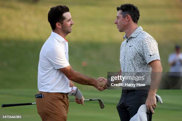 Denny McCarthy of the United States and Rory McIlroy of Northern Ireland shake hands on the 18th green after McIlroy won their match 2 up during day...