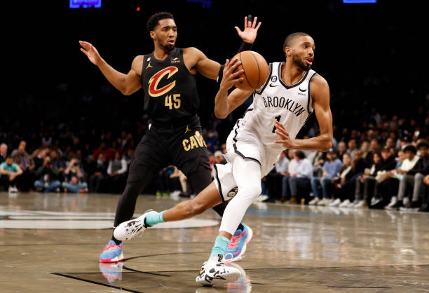 Mikal Bridges of the Brooklyn Nets dribbles as Donovan Mitchell of the Cleveland Cavaliers defends during the first half at Barclays Center on March...