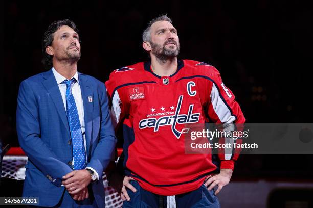 Alex Ovechkin of the Washington Capitals stands with NHLPA Assistant to the Executive Director Ron Hainsey while being honored during a pre-game...
