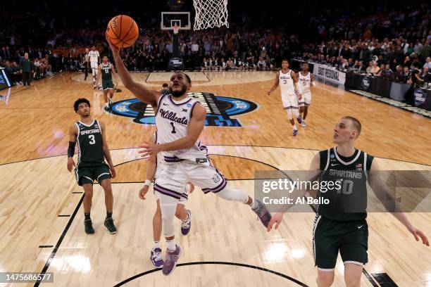 Markquis Nowell of the Kansas State Wildcats shoots the ball against Joey Hauser of the Michigan State Spartans during overtime in the Sweet 16 round...