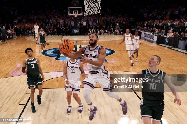 Markquis Nowell of the Kansas State Wildcats shoots the ball against Joey Hauser of the Michigan State Spartans during overtime in the Sweet 16 round...