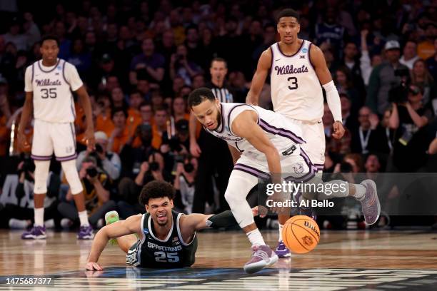 Malik Hall of the Michigan State Spartans dives for a loose ball recovered by Markquis Nowell of the Kansas State Wildcats during overtime in the...