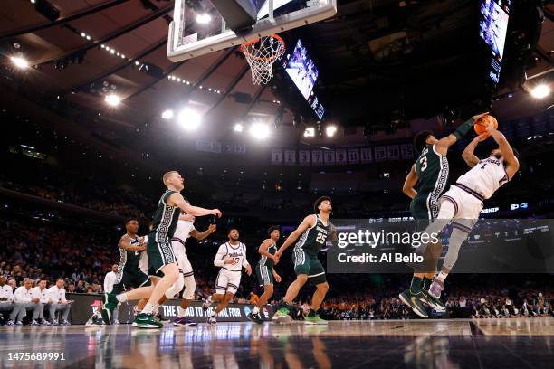 Markquis Nowell of the Kansas State Wildcats shoots the ball against Jaden Akins of the Michigan State Spartans during overtime in the Sweet 16 round...