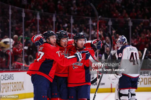 Sonny Milano of the Washington Capitals celebrates with T.J. Oshie and Rasmus Sandin after scoring a goal against Daniil Tarasov of the Columbus Blue...