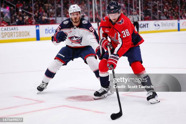 Rasmus Sandin of the Washington Capitals and Jack Roslovic of the Columbus Blue Jackets vie for the puck during the first period of the game at...