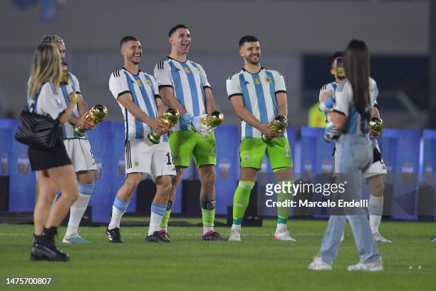 Guido Rodriguez, Emiliano Martinez, Geronimo Rulli of Argentina joke with the FIFA World Cup trophy during an international friendly match between...