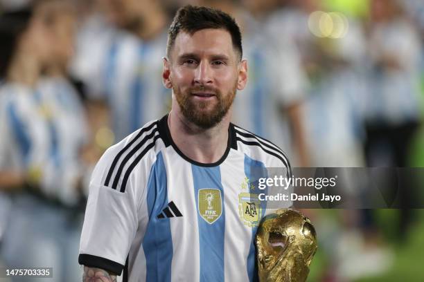 Lionel Messi of Argentina smiles with the FIFA World Cup trophy during the World Champions' celebrations after an international friendly match...