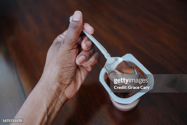 woman eats pudding - mousse stock-fotos und bilder