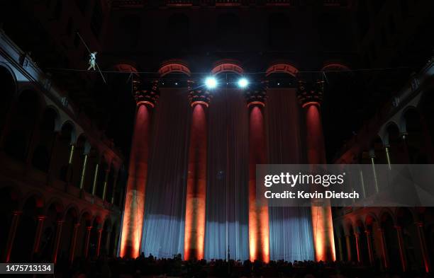 Philippe Petit, the French high wire artist, performs during his show "Wonder on the Wire," at the National Building Museum on March 23, 2023 in...