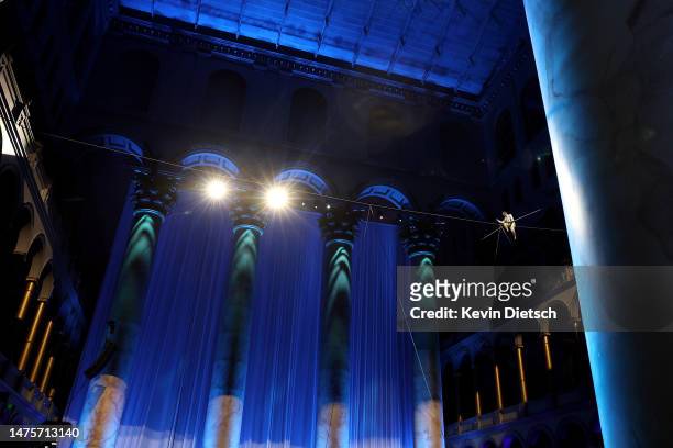 Philippe Petit, the French high wire artist, performs during his show "Wonder on the Wire," at the National Building Museum on March 23, 2023 in...