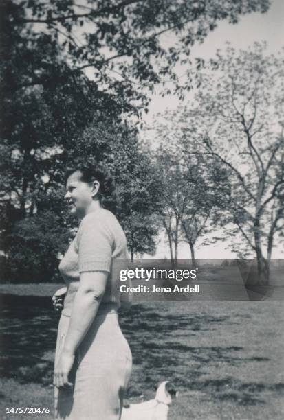 vintage woman candid portrait, candid woman walking dog in park, 1930s ancestry concept 1940s old family photo - 1930 1939 photos stock pictures, royalty-free photos & images