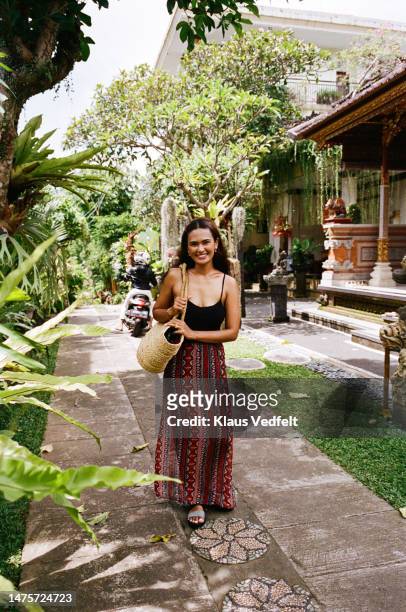 smiling woman with bag standing on footpath - sandal tree stock pictures, royalty-free photos & images