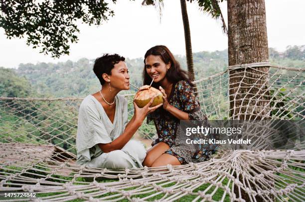 friends enjoying coconut water during vacation - 2 coconut drinks ストックフォトと画像