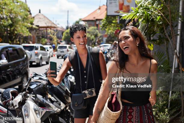 happy female friends enjoying vacation at street - indonesia street stock pictures, royalty-free photos & images