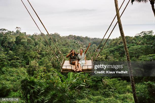 friends swinging together against forest - motion stock pictures, royalty-free photos & images