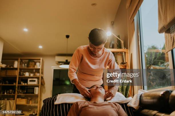 therapy massage with senior massage therapist. - schoonheidsspecialist natuur stockfoto's en -beelden