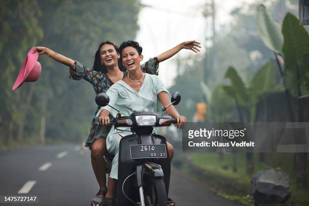 woman having fun with friend on scooter - short stock pictures, royalty-free photos & images