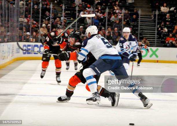 Brenden Dillon of the Winnipeg Jets plays the body on Trevor Zegras of the Anaheim Ducks during the third period of the game between the Winnipeg...