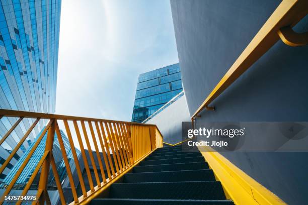 yellow staircase against skyscraper - buildings looking up stock pictures, royalty-free photos & images