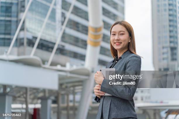young asian businesswoman using her digital tablet in a business district - succession planning stock pictures, royalty-free photos & images
