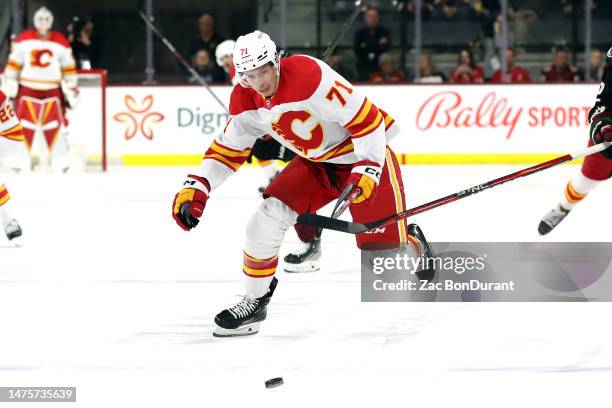 Walker Duehr of the Calgary Flames skates for a loose puck against the Arizona Coyotes at Mullett Arena on March 14, 2023 in Tempe, Arizona.