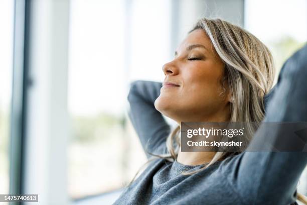 smiling woman resting with her eyes closed. - hands behind head stock pictures, royalty-free photos & images