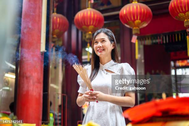 asian woman praying in chinese temple - chinese worship the god of fortune in guiyuan buddhist temple stockfoto's en -beelden