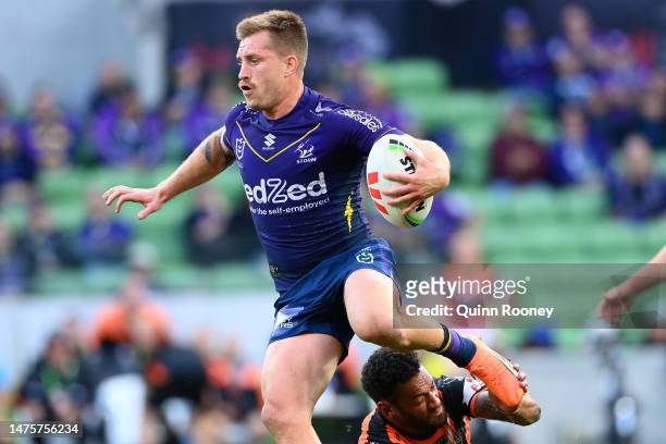 Cameron Munster of the Storm is tackled during the round four NRL match between the Melbourne Storm and Wests Tigers at AAMI Park on March 24, 2023...