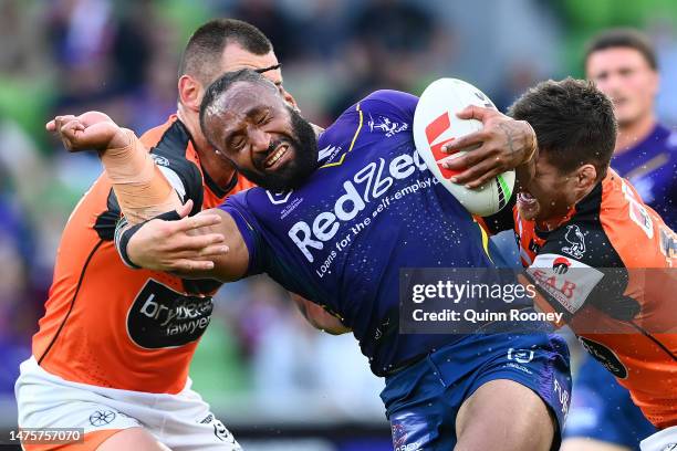 Justin Olam of the Storm is tackled during the round four NRL match between the Melbourne Storm and Wests Tigers at AAMI Park on March 24, 2023 in...