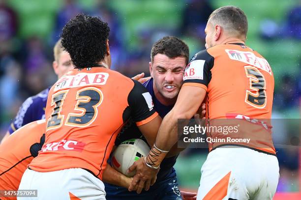 Trent Loiero of the Storm is tackled during the round four NRL match between the Melbourne Storm and Wests Tigers at AAMI Park on March 24, 2023 in...