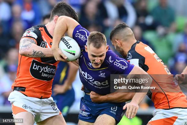 Alec MacDonald of the Storm is tackled during the round four NRL match between the Melbourne Storm and Wests Tigers at AAMI Park on March 24, 2023 in...