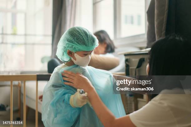 asian infant girl get dressed up surgeon and role-playing with family have fun and enjoy your domestic life at home. - cute nurses fotografías e imágenes de stock