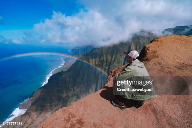 hombre mirando el arco iris sobre la costa de na pali en kauai isla de hawái ee.uu. - na pali fotografías e imágenes de stock