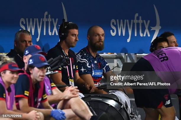 Max Gawn of the Demons is seen in the team bench after suffering an injury during the round two AFL match between Brisbane Lions and Melbourne Demons...