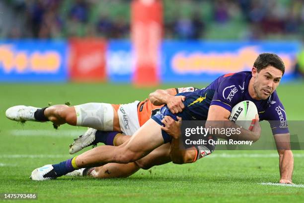 Nick Meaney of the Storm is tackled by Luke Brooks of the Wests Tigers during the round four NRL match between Melbourne Storm and Wests Tigers at...