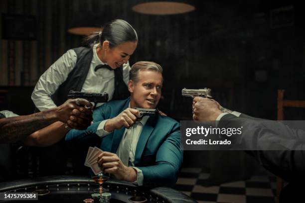 gangster gun violence at the poker table - casino worker stockfoto's en -beelden