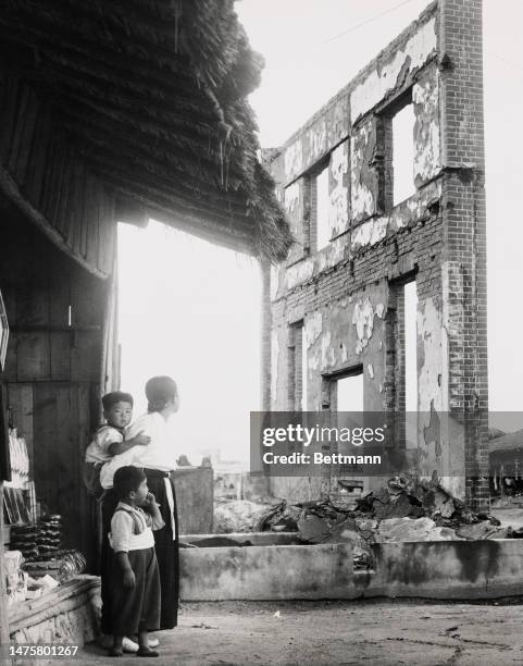 Mother and her children stand in the ruins of the city of Uijongbu, South Korea, where several battles between US and North Korean forces have been...