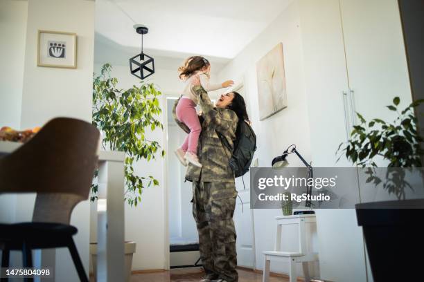 female soldier arriving home and surprising her little daughter - soldier coming home stock pictures, royalty-free photos & images