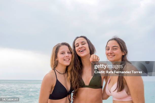 group of three young woman best friends enjoying the beach day. - woman swimsuit happy normal stock pictures, royalty-free photos & images