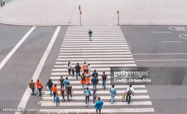 aerial view of a crowd crossing the street - volgen activiteit stockfoto's en -beelden