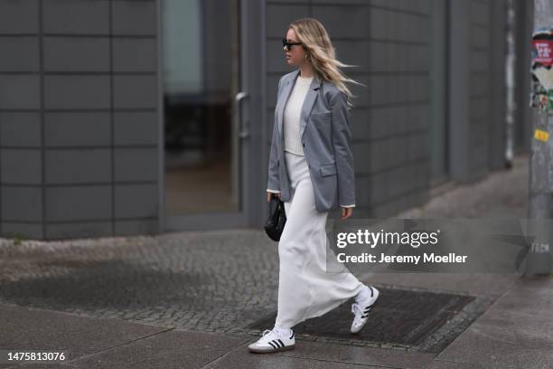 Isabelle Hartmann seen wearing YSL black sunglasses, House of Dagmar white silk long skirt, Vival Studio white cropped knit, silver earrings, Anine...